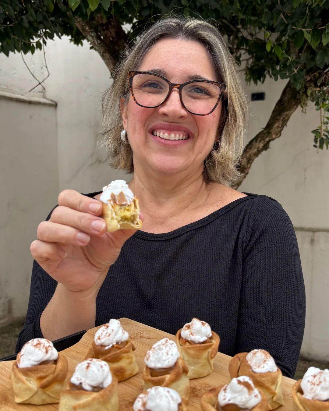 Dani segurando uma tábua com mini banoffees de massa de pastel